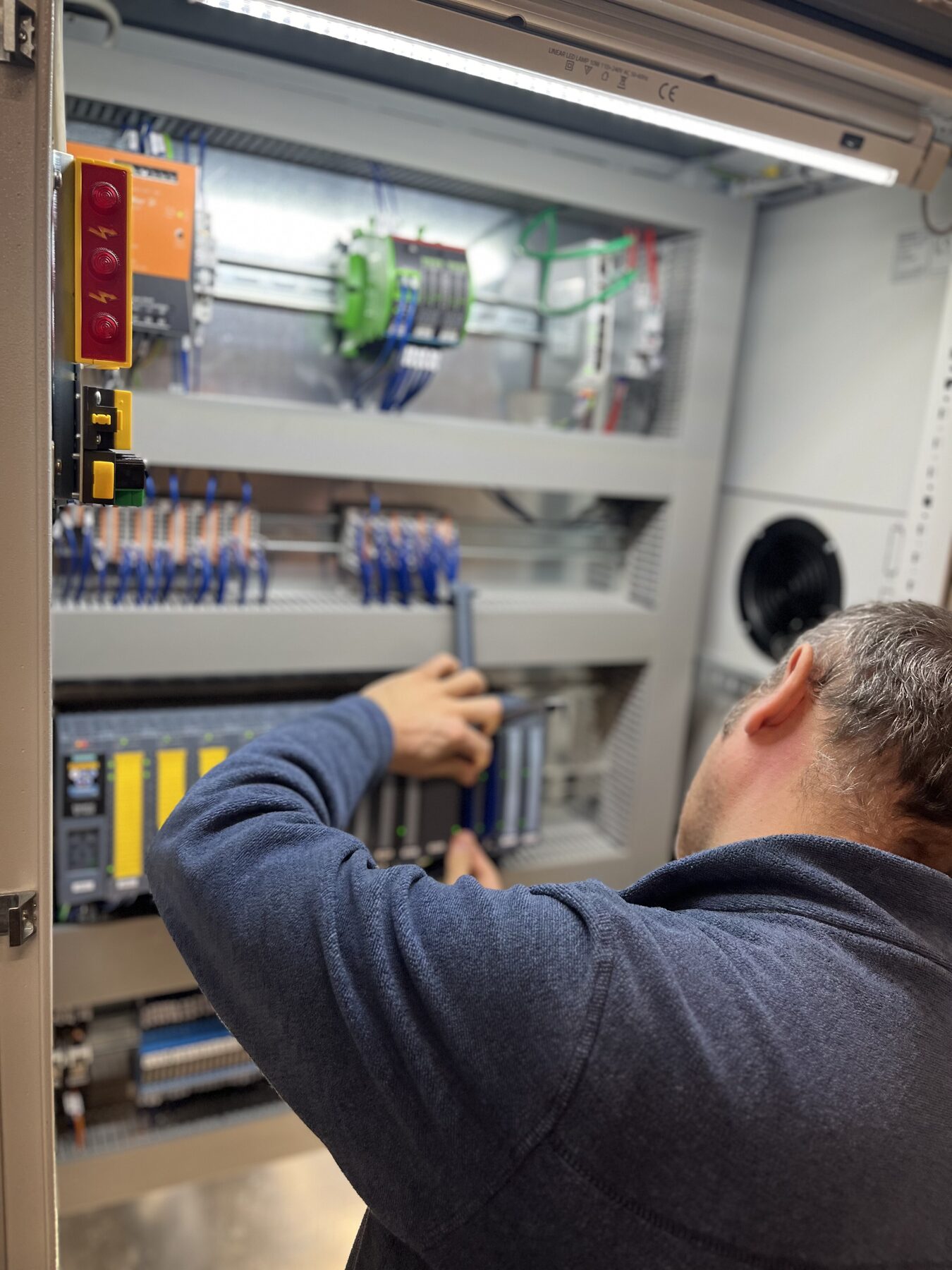 Tecnico ABC Automazione al lavoro su un quadro elettrico